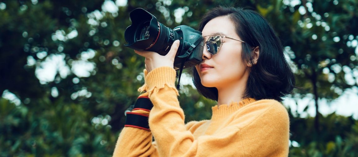 woman taking photo near tree